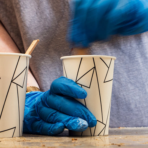 Teilnehmer mit Schutzhandschuhen beim Anmischen von Epoxidharz im Workshop bei Birdy Holzdesign