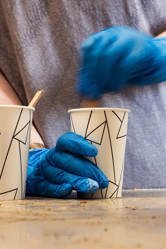 Teilnehmer mit Schutzhandschuhen beim Anmischen von Epoxidharz im Workshop bei Birdy Holzdesign