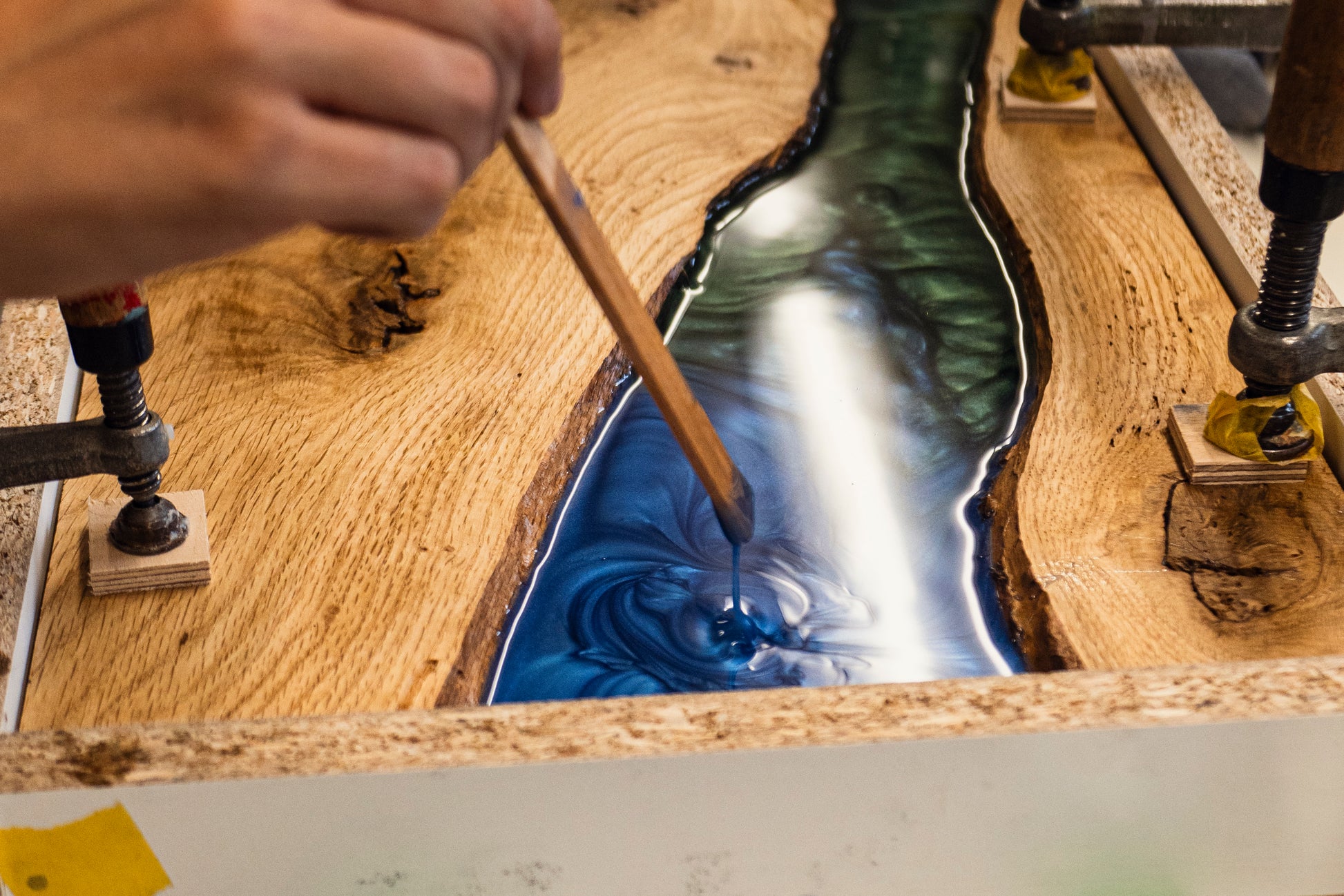 Epoxidharz in Blau und Grün wird in ein Holzservierbrett eingearbeitet – kreativer Prozess im Kurs bei Birdy Holzdesign Hamburg