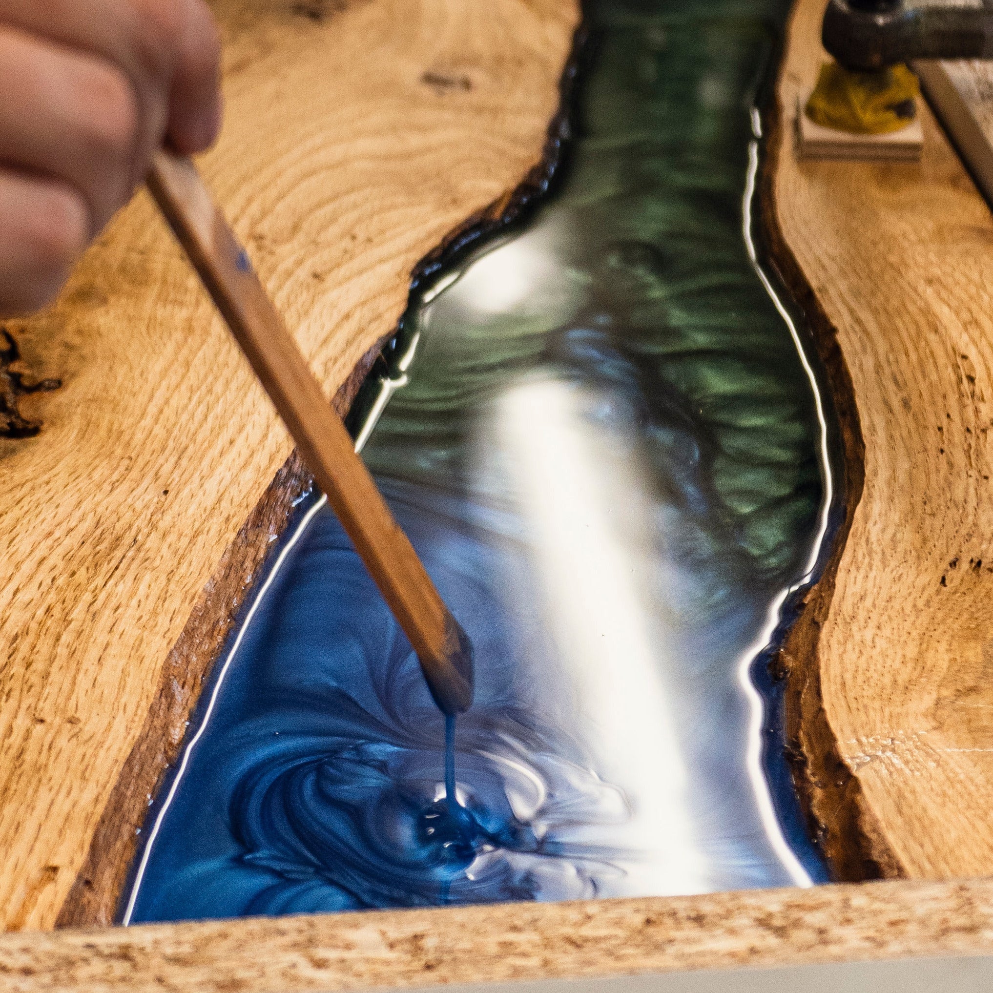 Epoxidharz in Blau und Grün wird in ein Holzservierbrett eingearbeitet – kreativer Prozess im Kurs bei Birdy Holzdesign Hamburg